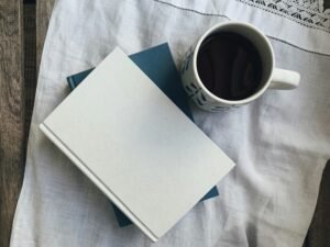 A minimalist setup with a blank white notebook and a cup of dark coffee, representing a clean slate to boost Zeigarnik effect productivity.