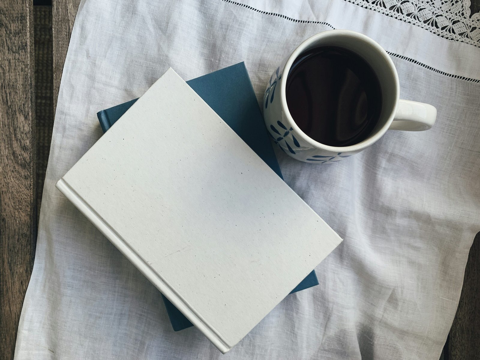 A minimalist setup with a blank white notebook and a cup of dark coffee, representing a clean slate to boost Zeigarnik effect productivity.