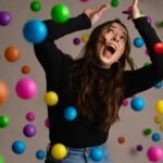 Woman overwhelmed by juggling many colorful balls, illustrating the inefficiency of multitasking compared to time blocking