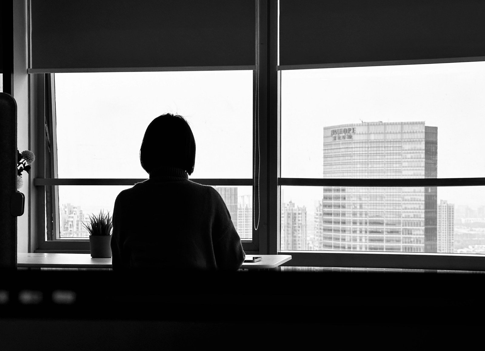 Office worker taking a mental break by looking out the window to recharge energy during the 17 minute rest phase.