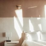 Sunlight hitting a minimalist bedroom wall in the morning, representing natural wake up cycles.
