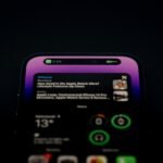 Smartphone lock screen lit up with multiple notifications, news alerts, and widgets in the dark, representing digital clutter.