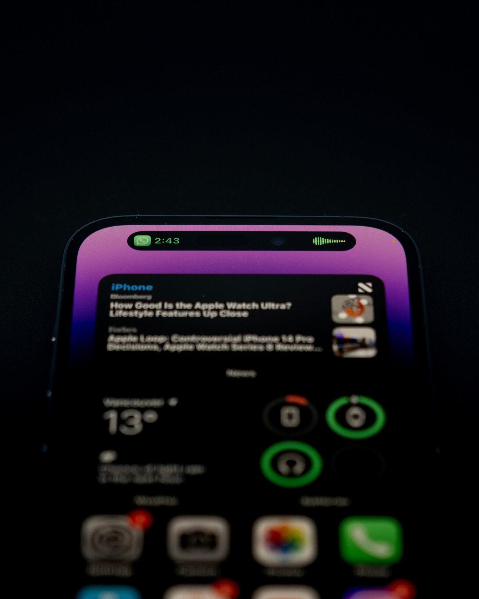 Smartphone lock screen lit up with multiple notifications, news alerts, and widgets in the dark, representing digital clutter.