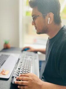 Man in deep focus wearing headphones and typing to trigger flow state.